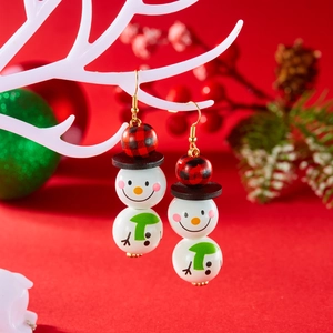 Détail de boucles d'oreilles bonhomme de neige en bois avec mini chapeau rouge