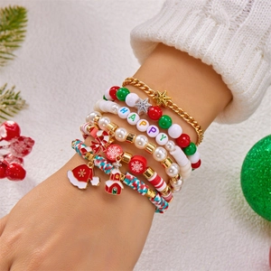 Weihnachts-Armbandset mit festlichen Anhängern und Perlen, getragen am Handgelenk