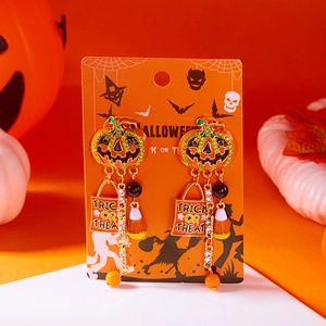 Detail of Halloween earrings featuring a crystal pumpkin and Trick or Treat candy charms