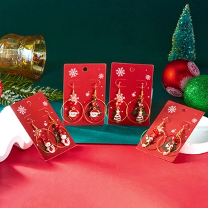 Detailed view of Christmas themed earrings set with colorful festive patterns on red cards