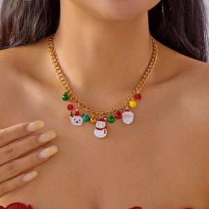 Primo piano di ciondoli natalizi in smalto su una collana a catena cubana placcata oro