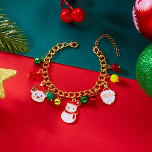 Dettaglio macro del bracciale natalizio con ciondoli in smalto colorato e maglie dorate