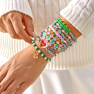 Detailed view of layered Christmas beaded bracelets featuring festive charms and letter beads