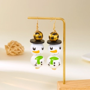 Détail des boucles d'oreilles bonhomme de neige en perles de bois avec écharpe verte