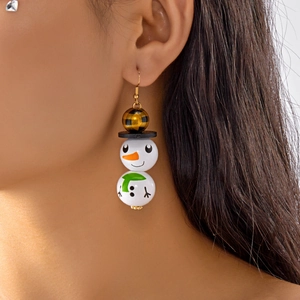 Gros plan d'un modèle portant des boucles d'oreilles bonhomme de neige en bois festif