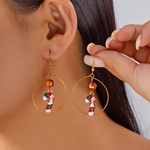 Model wearing a gold hoop earring featuring a colorful candy cane pendant with a red bow