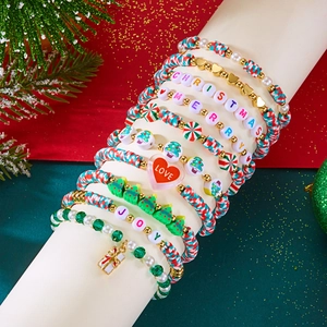 Macro detail of Christmas beaded bracelet set with clay charms and festive letter beads
