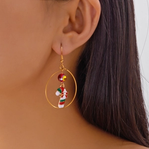 Detail of Christmas candy cane hoop earring with red faceted beads and festive bow