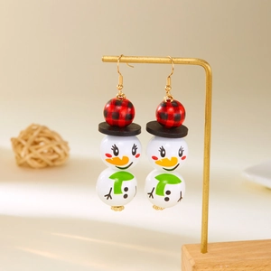 Détail de boucles d'oreilles bonhomme de neige avec perles en bois sur support doré