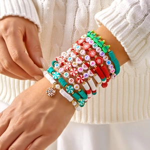 Detail of layered Christmas bead bracelets with Santa charms and festive letter beads
