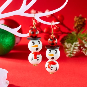 Détail de boucles d'oreilles bonhomme de neige en bois avec perles et motif à carreaux