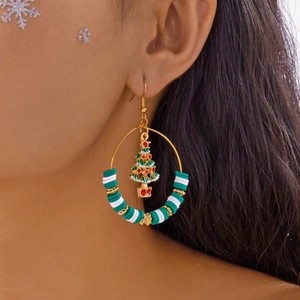 Detail of Christmas hoop earring with green Heishi beads and tree charm on a model