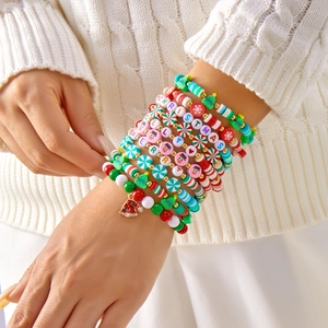Close-up of multilayer Christmas beaded bracelets with Santa hat charm on a winter sweater