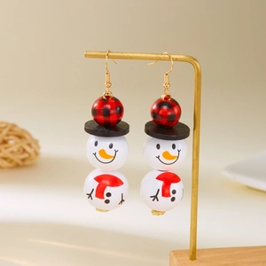 Détail de boucles d'oreilles bonhomme de neige avec perles en bois et crochets dorés