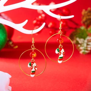 Detail of Christmas candy cane earrings with red beads on festive holiday display