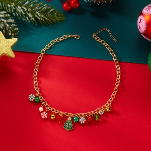 Dettaglio di una collana natalizia dorata con ciondoli a forma di albero, campane e dolci