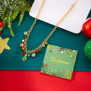 Dettaglio della collana di Natale con catena dorata e ciondoli a forma di caramelle e alberi