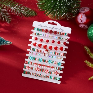Macro detail of Christmas beaded bracelets set with holiday charms on a red festive background