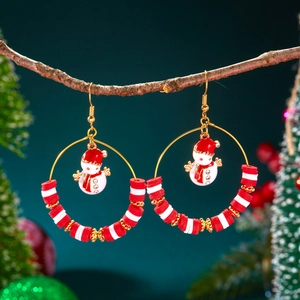 Detailed close-up of handmade Christmas hoop earrings with a snowman charm and red heishi beads