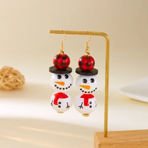 Détails macro des boucles d'oreilles bonhomme de neige en bois sur un présentoir