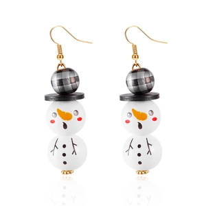 Détails macro des boucles d'oreilles bonhomme de neige avec perles en bois peintes