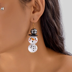 Gros plan de boucles d'oreilles bonhomme de neige en bois avec détails à carreaux