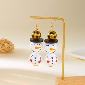 Détail de boucles d'oreilles bonhomme de neige avec perles en bois et charme festif