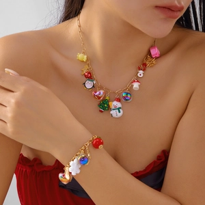 Detailed view of Christmas necklace and bracelet with snowflake, elk and tree charms