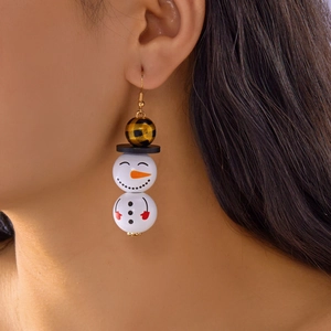 Détail d'une boucle d'oreille bonhomme de neige en perles de bois avec motif à carreaux