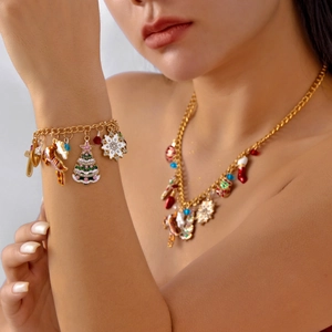 Close-up of golden Christmas jewelry set with enamel tree and reindeer charms on model