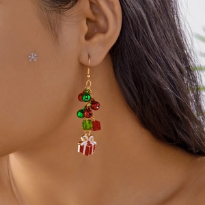 Close-up of Christmas hoop earrings with red gift box charms and festive bell beads
