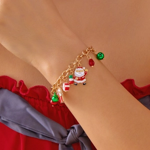 Dettaglio del braccialetto natalizio con ciondoli Babbo Natale, regalo e perle rosse