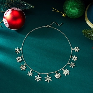 Detail of silver snowflake necklace with multiple crystal charms on green velvet