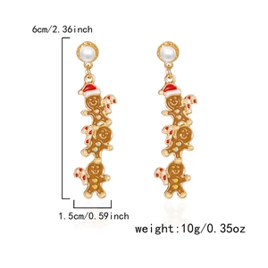 Détail de boucles d'oreilles bonhomme de pain d'épices avec perles et bonnets de Noël