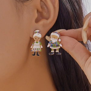 Gros plan de boucles d'oreilles Père Noël avec strass colorés et finition dorée
