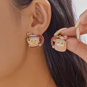 Gros plan de boucles d'oreilles de Noël Père Noël avec émail rouge et perles blanches