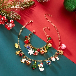 Detailed shot of Christmas jewelry set with snowman, elk, and tree charms on gold chains