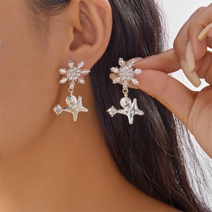 Détail de boucles d'oreilles flocon de neige avec bonhomme de pain d'épice cristallisé