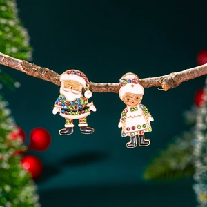 Détail de boucles d'oreilles de Noël avec figurines du Père Noël sur branches de bois