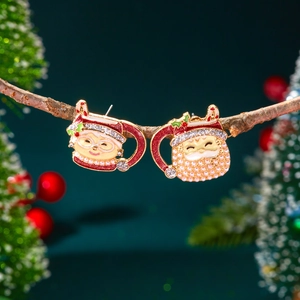 Vue détaillée de boucles d'oreilles de Noël en émail et perles sur une branche festive