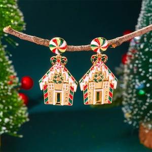 Détail de boucles d'oreilles maison en pain d'épices avec émail coloré sur branche bois