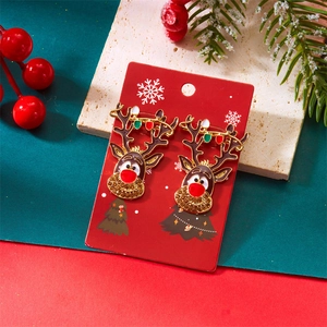 Détail des boucles d'oreilles renne de Noël avec perles colorées sur branche enneigée