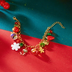Christmas charm bracelet with snowflakes, gingerbread man and red beads on gold chain