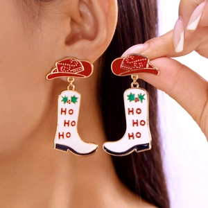 Detailopname van kerst cowboylaars oorbellen met HO HO HO tekst bij een model