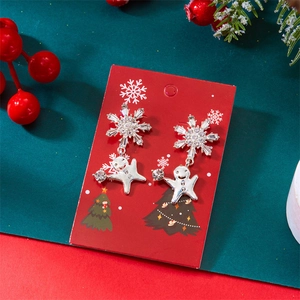 Détail de boucles d'oreilles bonhomme de pain d'épices avec strass sur carte de Noël