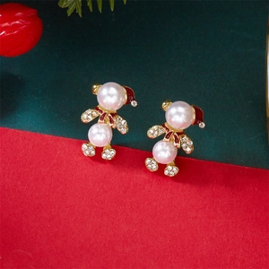 Détail de boucles d'oreilles ours en perles de Noël avec chapeau en émail rouge et zircons