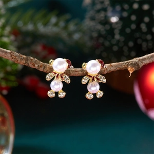 Détails des boucles d'oreilles ours de Noël avec perles et émail rouge sur branche