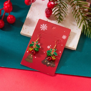 Detail of Christmas holly leaf earrings with red, green and gold bells on festive card