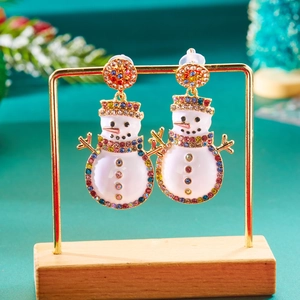 Detail van sneeuwpop oorbellen met gekleurde strass-steentjes op een gouden houder