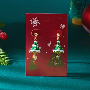 Detail van de kerstboom oorbellen met gouden ornamenten en transparante druppelhangers